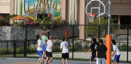 students play a game of pickup basketball on the court outside of McConnell Hall